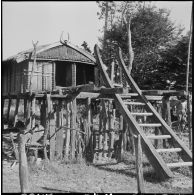 Habitation traditionnelle Kha en bois sur pilotis ornée de décorations, dans un village au sud d'Attapeu (Laos).