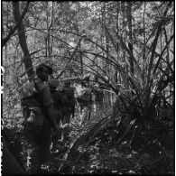 Des chasseurs de la 6e compagnie du 2e bataillon Lao progressent sur un sentier dans la forêt tropicale au cours de l'opération Pakha, dans la province d'Attapeu.