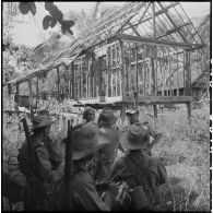 Arrivés dans un village en ruines, des officiers du 2e bataillon de chasseurs vietnamiens (2e BCL) mettent au point le cantonnement.