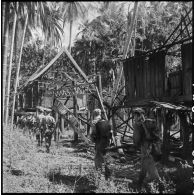 Arrivée des éléments du 2e bataillon de chasseurs laotiens dans un village en ruines.