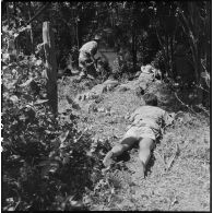 Des chasseurs du 2e bataillon de chasseurs laotien (2e BCL) se tiennent en position allongée alors que des partisans du Vietminh dissimulés de l'autre côté de la rivière ont ouvert le feu.