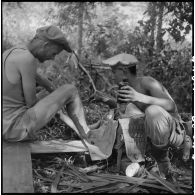  Le lieutenant Pardigon du 2e bataillon de chasseurs laotiens (2e BCL) se fait soigner des morsures de sangsues par un infirmier dans la forêt.