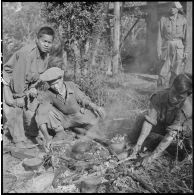 Des chasseurs du 2e bataillon de chasseurs laotiens (2e BCL) se préparent de la viande sur le lieu de cantonnement.