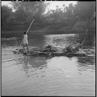 Transport de paquetages du 2e bataillon de chasseurs laotiens (2e BCL) sur un radeau pour permettre leur franchissement de la rivière.