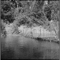 Construction d'un pont de bambous sur la rivière Sé Kampo par des chasseurs du 2e bataillon de chasseurs laotiens et des jeunes garçons.