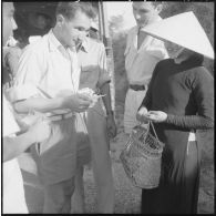 Inspecteurs de la police judiciaire militaire contrôlant les papiers d'une femme vietnamienne à Nha Trang.