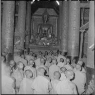 Bonzes et bonzillons devant la statue du grand Bouddha au Vat Visoun, Luang Prabang.