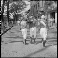 Des jeunes jockeys se baladent dans une rue de Saigon.