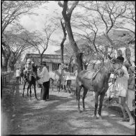Les jeunes jockeys s'installent sur les cheveux pour une course à l'hippodrome de Phu Tho à Saigon.