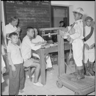 Les jeunes jockeys sont pesés avec leur selle avant une course à l'hippodrome de Phu Tho à Saigon.