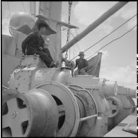 Contrôle d'un treuil par un Vietnamien à bord d'un navire au cours du déchargement de marchandises au port de Saigon.
