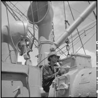 Contrôle d'un treuil par un Vietnamien à bord d'un navire au cours du déchargement de marchandises au port de Saigon.