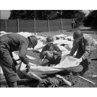 Normandie 1944 (actualités américaines) - Préparatifs d'enterrement de soldats américains au cimetière militaire de La Cambe.
