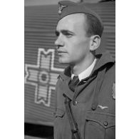 Portrait d'un pilote roumain, derrière lui un avion de transport Junkers Ju-52 aux couleurs roumaines.