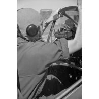 Sur le terrain de Mamaia, un pilote roumain du Grupul 9 s'équipe à bord du chasseur IAR 80 numéroté 146.