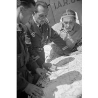 Des officiers du Grupul 9 observent une carte de Bucarest posée sur la queue d'un chasseur IAR 80.