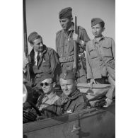 Portrait de groupe de membres du 9e groupe de chasse roumain dans une voiture et armés de fusils de chasse.