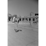 Un jeune garçon joue avec sa trottinette.