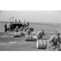 Déchargement d'une péniche de la Kriegsmarine et prise en charge de carburant par la Luftwaffe.