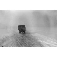 Dans une tempête de neige, la progression sur une route glacée.