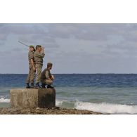 Des légionnaires du 5e régiment étranger (5e RE) en patrouille sur l'atoll de Moruroa observent la mer, à la recherche du cinquième zodiac de Greenpeace introuvable lors de l'arraisonnement du navire Rainbow Warrior II.