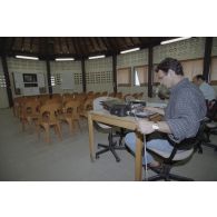 Dans la salle de presse installée par le SIRPA sur l'atoll de Moruroa, un preneur de son contrôle son magnétophone à bandes de type Nagra.