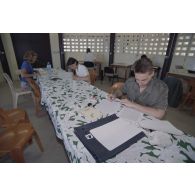 Dans la salle de presse installée par le SIRPA sur l'atoll de Moruroa, des journalistes préparent leurs papiers.