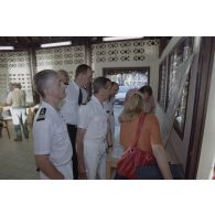 Les officiers du SIRPA et des journalistes lisent la revue de presse affichée sur un mur de la salle de presse installée par le SIRPA sur l'atoll de Moruroa.