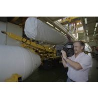 Un caméraman de RFO filme un plan sur la barge Manutéré dans le lagon de l'atoll de Moruroa.