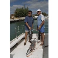 Retour au port après une partie de pêche à la traîne sur une petite vedette en bordure de l'atoll de Moruroa des premier et deuxième adjoint du maire de Papeete, Raymond Van Bastolaer et Patrick Bordet (casquette), lors d'une visite de membres du gouvernement et d'élus du territoire polynésiens. De nombreux poissons ont été attrapés, ici un thazard noir.