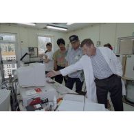 La délégation de membres du gouvernement et d'élus du territoire polynésienn, dont Eugène Bessert, maire de Papara (casquette bleue), visite les laboratoires du service mixte de surveillance radiologique et biologique de l'homme et de l'environnement (SMSRB) sur l'atoll de Moruroa.
