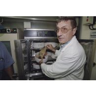 La délégation de membres du gouvernement et d'élus du territoire polynésien visite les laboratoires du service mixte de surveillance radiologique et biologique de l'homme et de l'environnement (SMSRB) sur l'atoll de Moruroa. Un technicien montre un poisson prélevé.
