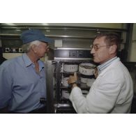 La délégation de membres du gouvernement et d'élus du territoire polynésien visite les laboratoires du service mixte de surveillance radiologique et biologique de l'homme et de l'environnement (SMSRB) sur l'atoll de Moruroa. Un technicien montre un poisson prélevé à Gaston Flosse, président de la Polynésie française.