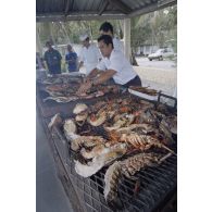 Dégustation de langoustes et poissons grillés, pêchés sur site, par la délégation de membres du gouvernement et d'élus du territoire polynésien en visite sur l'atoll de Moruroa.