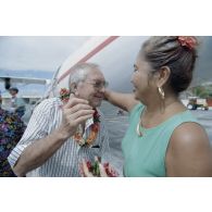 Une habitante remet un collier de fleurs de tiaré à Gaston Flosse, président de la Polynésie française, lors de la visite de membres du gouvernement et d'élus du territoire polynésien sur l'atoll de Moruroa.