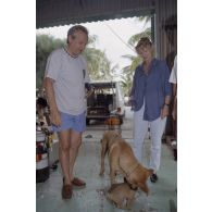 Jean-Jacques de Peretti, ministre de l'Outre-mer, et Marine Jacquemin, journaliste de TF1, avec les chiens Greenpeace, Rainbow Warrior I ou Rainbow Warrior II, mascottes du service mixte de surveillance radiologique et biologique (SMSRB) de Moruroa, lors des préparatifs avant le départ en plongée sous-marine.