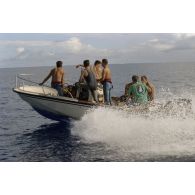 Des plongeurs du service mixte de surveillance radiologique et biologique (SMSRB) patrouillent dans un canot Boston.