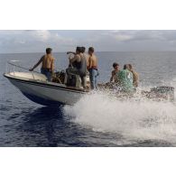 Des plongeurs du service mixte de surveillance radiologique et biologique (SMSRB) patrouillent dans un canot Boston.