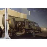 Reflet d'un camion-citerne du service des essences des armées (SEA) sur la cabine d'un hélicoptère Super-Puma de l’escadron de transport d’hélicoptères d’outre-mer (ETOM) 82 stationné sur l'aéroport de l'atoll de Moruroa.