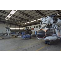 Montage d'hélicoptères Puma SA-330 de l’escadron de transport d’outre-mer (ETOM) 52 et Super-Puma AS-332  dans un hangar de l'atoll de Moruroa.
