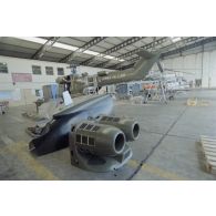 Montage d'hélicoptères Puma SA-330 et Super-Puma AS-332 dans un hangar de l’escadron de transport d’outre-mer (ETOM) 82 de Moruroa. Au premier plan, des pièces de carénage.