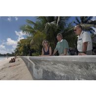 Jean-Jacques de Peretti, ministre de l'Outre-mer, et Marine Jacquemin, journaliste de TF1, en compagnie du colonel M. Bertrand, commandant en second (CSD) de la base interarmées (BIA), devant la plage sur l'atoll de Morurua.