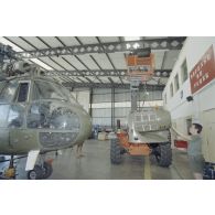 Montage de pièce de carénage d'un hélicoptère Puma SA-330 de l’escadron de transport d’outre-mer (ETOM) 82 de Moruroa.