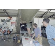 Montage du système de transmission de l'ECPA dans l'hélicoptère de l’escadron de transport d’outre-mer (ETOM) 52 dans un hangar de l'atoll de Moruroa, en présence de Christian Dion, technicien vidéo de l'ECPA.