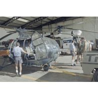 Préparation d'hélicoptères Alouette III de la Marine et Super-Puma AS-332 dans un hangar de l’escadron de transport d’outre-mer (ETOM) 82 de Moruroa.