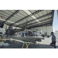 Préparation d'hélicoptères Puma SA-330, Alouette III de la Marine et Super-Puma AS-332 dans un hangar de l’escadron de transport d’outre-mer (ETOM) 82 de Moruroa. Montage du système de transmission de l'ECPA sur le Puma, en présence de Christian Dion, technicien de l'ECPA.