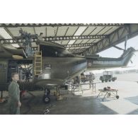 Montage du système de transmission de l'ECPA dans l'hélicoptère de l’escadron de transport d’outre-mer (ETOM) 52 dans un hangar de l'atoll de Moruroa.