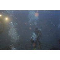 Vue sous-marine pendant la plongée du ministre de l'Outre-mer, avec un caméraman de la télévision TF1, sur la tulipe d'un puits de tir d'expérimentation nucléaire sous lagon.