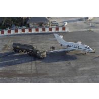 Vue aérienne du ravitaillement en carburant d'un avion de reconnaissance Gardian de l'escadrille 12S de Papeete sur l'aéroport du Moruroa par un camion-citerne du service des essences des Armées (SEA).
