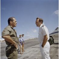 L'adjudant Gabert de l'ECPA et le capitaine de corvette Ollivier du SIRPA sur le départ à l'aéroport de Moruroa par avion Dassault-Bréguet Gardian. En arrière-plan, l'équipe de piste.